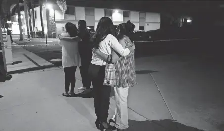  ?? JAE C. HONG/ AP ?? People comfort each other near a building where four people were killed Wednesday evening.