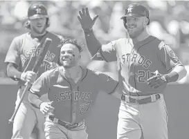  ?? Ben Margot / Associated Press ?? Jose Altuve (27) was stoked to greet Derek Fisher (21) at the plate after Fisher followed Max Stassi’s solo homer with one of his own to put the Astros up 2-1.