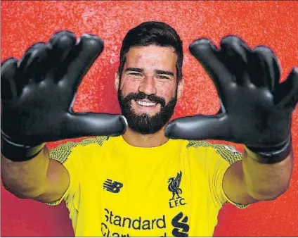  ?? FOTO: EFE ?? Alisson, con el escudo del Liverpool A sus 25 años, el portero de la selección brasileña ha firmado un contrato hasta 2023