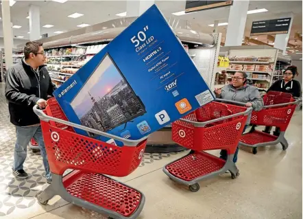  ??  ?? Customers navigate the aisles during the Black Friday sale at a Target store in Chicago. This year’s Black Friday saw many stores across America offering entertainm­ent and free gifts to attract customers, and a sharp increase in online sales.