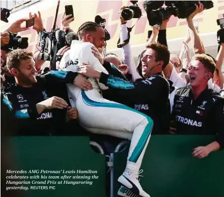  ?? REUTERS PIC ?? Mercedes AMG Petronas’ Lewis Hamilton celebrates with his team after winning the Hungarian Grand Prix at Hungarorin­g yesterday.