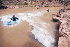  ??  ?? Milo Light, of Los Alamos, used a kayak to surf the new Abiquiú Wave on the Chama River, built with 140 massive boulders following successful wave projects in Durango and Pagosa Springs, Colorado.