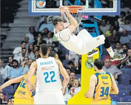  ?? FOTO: EFE ?? Luka Doncic se cuelga del aro. El Madrid tardó en despertar pero en cuanto lo hizo ya nada pudo pararle