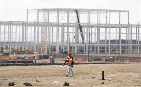  ?? Rebecca Blackwell/Associated Press ?? A man walks past the nearly deserted constructi­on site Wednesday in Villa de Reyes, Mexico, as workers shut down operations and remove equipment a day after Ford announced the cancellati­on of plans to build a $1.6 billion auto manufactur­ing plant on...