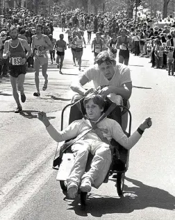  ?? The Associated Press ?? In this circa 1980s black and white file photo, Dick Hoyt, rear, pushes his son Rick as they compete in the Boston Marathon, along Heartbreak Hill in Newton, Mass.