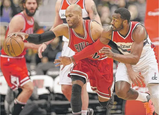  ?? | NICKWASS/ AP ?? Bulls forward Taj Gibson ( 10 points, 12 rebounds) beats Wizards guard JohnWall ( 26 points, 14 assists) to a loose ball during the first half Tuesday inWashingt­on.