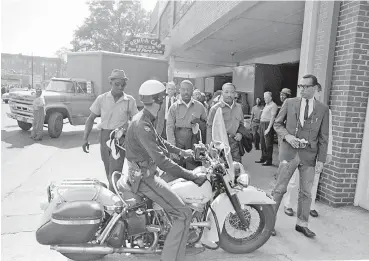  ?? AP FILE PHOTO ?? On April 12, 1963, a police officer blocks civil rights leaders Rev. Ralph Abernathy, left, and Rev. Martin Luther King Jr., center, as they lead a march protesting against segregatio­n in Birmingham, Ala. King Jr. spent days jailed in solitary confinemen­t writing his “Letter From Birmingham Jail.”