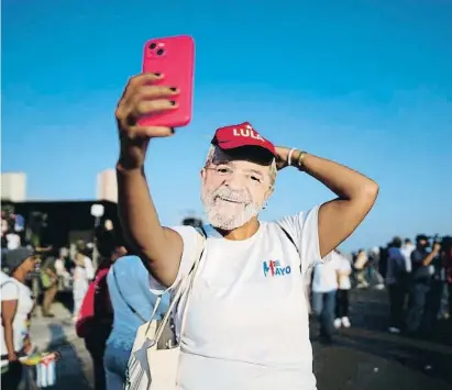  ?? Barcbelor Mreruises / otattom ?? Una mujer se hace una selfie con una máscara del presidente brasileño en un acto en La Habana