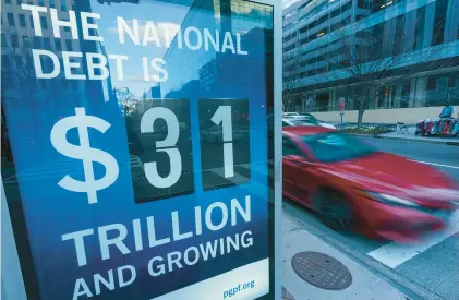  ?? MANDEL NGAN/GETTY-AFP ?? A sign at a Washington bus shelter shows the national debt Jan. 20.