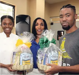  ??  ?? Left: Shantoy Keith (left) and Ryan Ebanks emerged the winners of the bun-eating competitio­n. They are presented with their gift baskets by Donna-Kaye Sharpe.