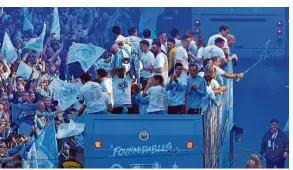  ?? — AFP ?? Party: Manchester City players and officials take part in an open-top bus parade on Monday to celebrate their treble success.
