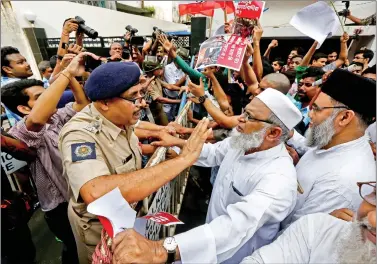  ?? REUTERS ?? A police officer tries to stop a demonstrat­or of Students Islamic Organisati­on of India (SIO) from breaking a police barricade during a protest rally against killing of Rohingya people in Myanmar, near Myanmar consulate in Kolkata, on Wednesday.