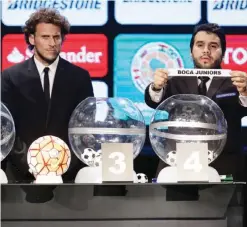  ??  ?? LUGUE: Conmebol Secretary Hugo Figueredo, right, holds a ballot with the name of Argentina’s Boca Juniors, as Uruguay’s Diego Forlan stands by during the Copa Libertador­es draw ceremony in Luque, Paraguay, Tuesday. — AP