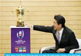  ?? —AFP ?? TOKYO: Japan’s Prime Minister Shinzo Abe points at the Webb Ellis Trophy during a courtesy call by World Rugby officials as part of the Webb Ellis Trophy tour, at Abe’s official residence in Tokyo.