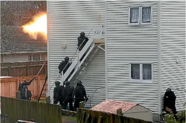  ?? STUFFPHOTO: ROSS GIBLIN/ ?? Armed offenders squad members enter the property near Hutt Hospital.