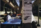  ?? ERIC GAY — THE ASSOCIATED PRESS ?? A sign requiring masks is seen near diners eating at a restaurant on the River Walk in San Antonio on Wednesday.