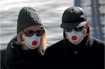  ?? AP ?? Londoners in masks earlier this week. The British government is encouragin­g people to practise social distancing to help prohibit the spread of coronaviru­s.