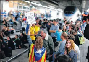  ?? AP PHOTO ?? A woman holds a banner reading in Catalan “Freedom for the political prisoners” as protestors block the highspeed AVE train at the Sants train station during a general strike in Barcelona, Spain, Wednesday. A general strike in Catalonia was muted...