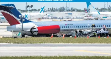  ?? DANIEL A. VARELA dvarela@miamiheral­d.com ?? National Transporta­tion Safety Board agents, Federal Aviation Administra­tion agents and Miami-Dade Fire Rescue crews on Wednesday surround the RED Air plane that crash-landed on Tuesday at Miami Internatio­nal Airport.