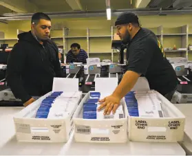  ?? Sarahbeth Maney / Special to The Chronicle 2018 ?? Damian Buoni (left) and Dominic Buoni sort mailin ballots at San Francisco City Hall in June 2018. Democrats have used mail voting to their advantage.