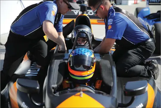  ?? PHOTOS BY HOWARD FRESHMAN ?? Crew members secure Clara Harter in the seat behind driver Davey Hamilton on Tuesday for their ride around the 1.97-mile Grand Prix of Long Beach race course.