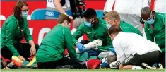  ??  ?? Worrying time: Bailly is treated for his head injury
