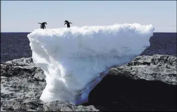  ?? PAULINE ASKIN/REUTERS FILE ?? Two Adelie penguins stand atop a block of melting ice on a rocky shoreline at Cape Denison, Commonweal­th Bay, in East Antarctica in 2010.