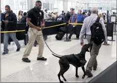  ?? CARL JUSTE/MIAMI HERALD FILE PHOTOGRAPH ?? TSA officer Cedric Belvin and German short-hair pointer Angus search departing passengers for explosives at Miami Internatio­nal Airport, Concourse J, South TSA checkpoint on Nov. 21, 2018 in Miami, Fla.