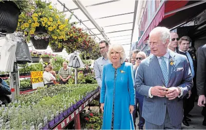  ?? PAUL CHIASSON THE CANADIAN PRESS ?? Prince Charles and Camilla, Duchess of Cornwall, check out plants for sale at the Byward Market in Ottawa on their Canadian Royal Tour, Wednesday.