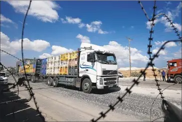  ?? Said Khatib AFP/Getty Images ?? WITH THE reopening of the Kerem Shalom crossing, trucks carrying building supplies, foodstuffs, textiles, animal feed, fuel, gas and other products rumbled into the Gaza Strip after five weeks of lockdown.