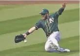  ?? Ashley Landis / Associated Press ?? A’s left fielder Robbie Grossman can’t catch a ball hit by Houston’s Josh Reddick — one of six hits for the Astros in a fiverun fourth inning.