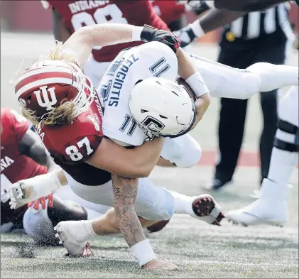  ?? DARRON CUMMINGS/AP ?? Connecticu­t quarterbac­k Jack Zergiotis (11) is sacked by Indiana defensive lineman Michael Ziemba during the second half on Saturday in Bloomingto­n, Ind. Indiana won 38-3, scoring 38 unanswered points after an early field goal by the Huskies.