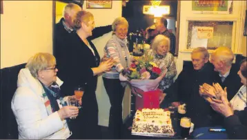  ?? Lysaght) (Pic: Jim ?? Nuala being presented with a cake and a bouquet of flowers by Mary Bartley on behalf of all her customers, also present are Bridie O’Donnell, Mary and Liam Power, J.J. Kelly and Joe Coughlan.