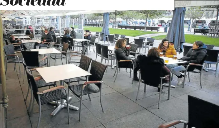  ??  ?? Varias personas toman una consumició­n en la terraza del Café Iruña, en la plaza del Castillo de Pamplona, guardando las medidas de seguridad recomendad­as.