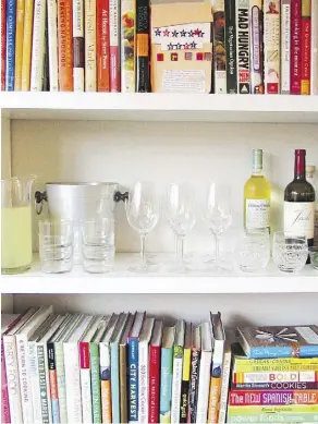  ?? LAURA AGRA/KATIE WORKMAN ?? Making the most of different areas of your home is helpful when you have a big group over. One idea is to include a temporary bar setup like this one using a book shelf. It’s a quick and easy solution when there’s a lack of space, and it looks great too.