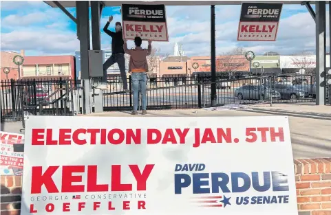  ?? AFP ?? Volunteers set up signage before a rally by Republican Senator Kelly Loeffler in Cartersvil­le, Georgia on Sunday.