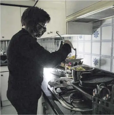  ?? Ferran Nadeu ?? Una mujer utiliza linternas para cocinar debido a los cortes de luz en un barrio de Figueres, el pasado enero.