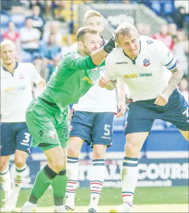  ??  ?? CRASH: Bolton’s goalkeeper Mark Howard and defender David Wheater collide