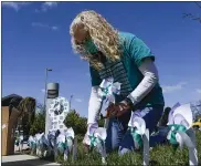  ??  ?? Beth Garrigan, the CEO of Safe Berks, sets up pinwheels along with other staff at Safe Berks in Reading Friday afternoon April 2, 2021. Staff members put out 250 pinwheels to symbolize local victims of sexual assault as part of their event, “Recognizin­g & Rememberin­g Victims of Sexual Assault – Known & Unknown,” during Sexual Assault Awareness Month.