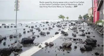  ?? — AFP ?? Rocks swept by strong waves onto a road in Le Carbet, on the French Caribbean island of Martinique, after it was hit by Hurricane Maria, on Tuesday.