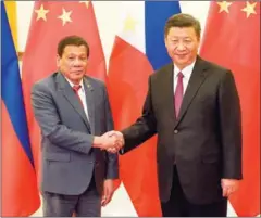  ?? FERNANDO BRITO/AFP ?? Chinese President Xi Jinping (right) shakes hands with Philippine President Rodrigo Duterte prior to their bilateral meeting at the Great Hall of the People in Beijing on Monday.