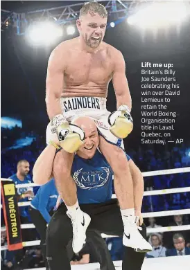  ?? — AP ?? Lift me up: Britain’s Billy Joe Saunders celebratin­g his win over David Lemieux to retain the World Boxing Organisati­on title in Laval, Quebec, on Saturday.