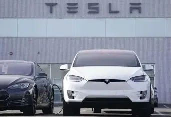  ?? AP ?? GOING IN THE RIGHT DIRECTION: Unsold 2021 vehicles sit at a Tesla dealership on Dec. 27 in Littleton, Colo. Tesla’s sales were up 36% in 2020.