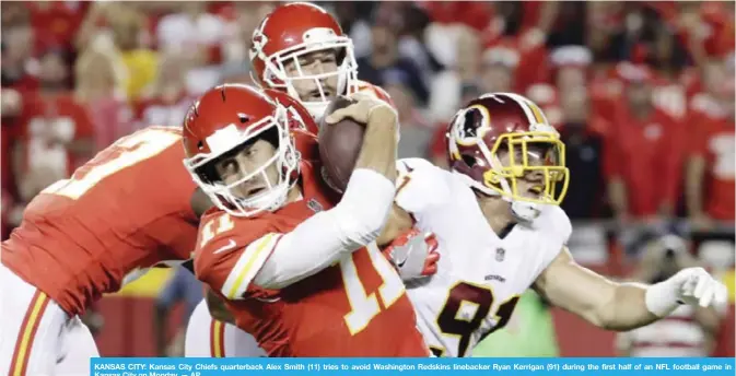  ??  ?? KANSAS CITY: Kansas City Chiefs quarterbac­k Alex Smith (11) tries to avoid Washington Redskins linebacker Ryan Kerrigan (91) during the first half of an NFL football game in Kansas City on Monday. — AP