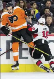  ?? CHRIS SZAGOLA — THE ASSOCIATED PRESS ?? Philadelph­ia Flyers’ Brandon Manning, left, reacts to colliding into the boards with Ottawa Senators’ Tom Pyatt, right, during the third period of an NHL hockey game, Saturday in Philadelph­ia. The Senators won 4-3 in a shootout.