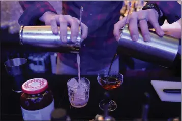  ?? JULIO CORTEZ — THE ASSOCIATED PRESS ?? Gregory Megner, general manager and mixologist at Baltimore Spirits Co., pours two mixed drinks — a “Peanut Butter Jelly Thyme” on the left, and a “Best Cup of Coffee in a Manhattan” — containing whiskey distilled on premises on Wednesday in Baltimore.