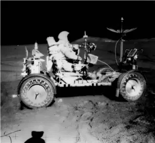  ?? (Getty) ?? Scott transports samp l es of rocks and soi l back to the Fa l con lunar module on the LRV