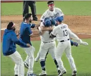  ?? Robert Gauthier Los Angeles Times ?? DODGERS MOB pitcher Julio Urías after the last out of the World Series victory against the Rays.