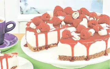  ?? A360 ?? This cheesecake is garnished with white chocolate curls and fresh raspberrie­s.