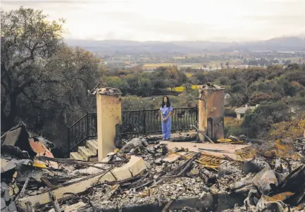  ?? Gabrielle Lurie / The Chronicle ?? Stephanie Huang stands where her home was destroyed in the Tubbs Fire in Santa Rosa’s Fountaingr­ove neighborho­od. Huang, a doctor, and her family fled with the clothes they had on, so she has worn her medical scrubs every day since.